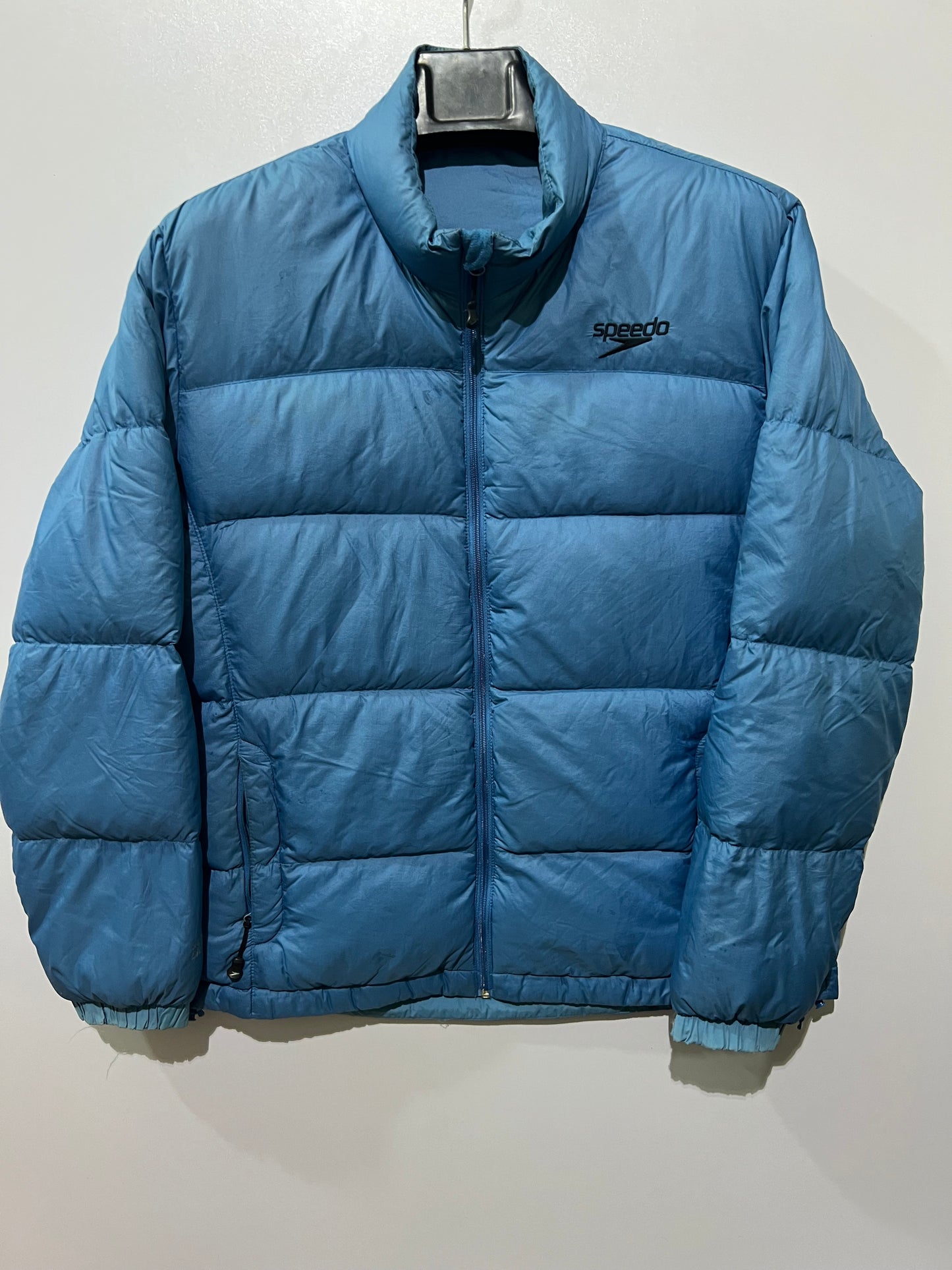 Speedo puffer jacket features a high collar and quilted construction for warmth.