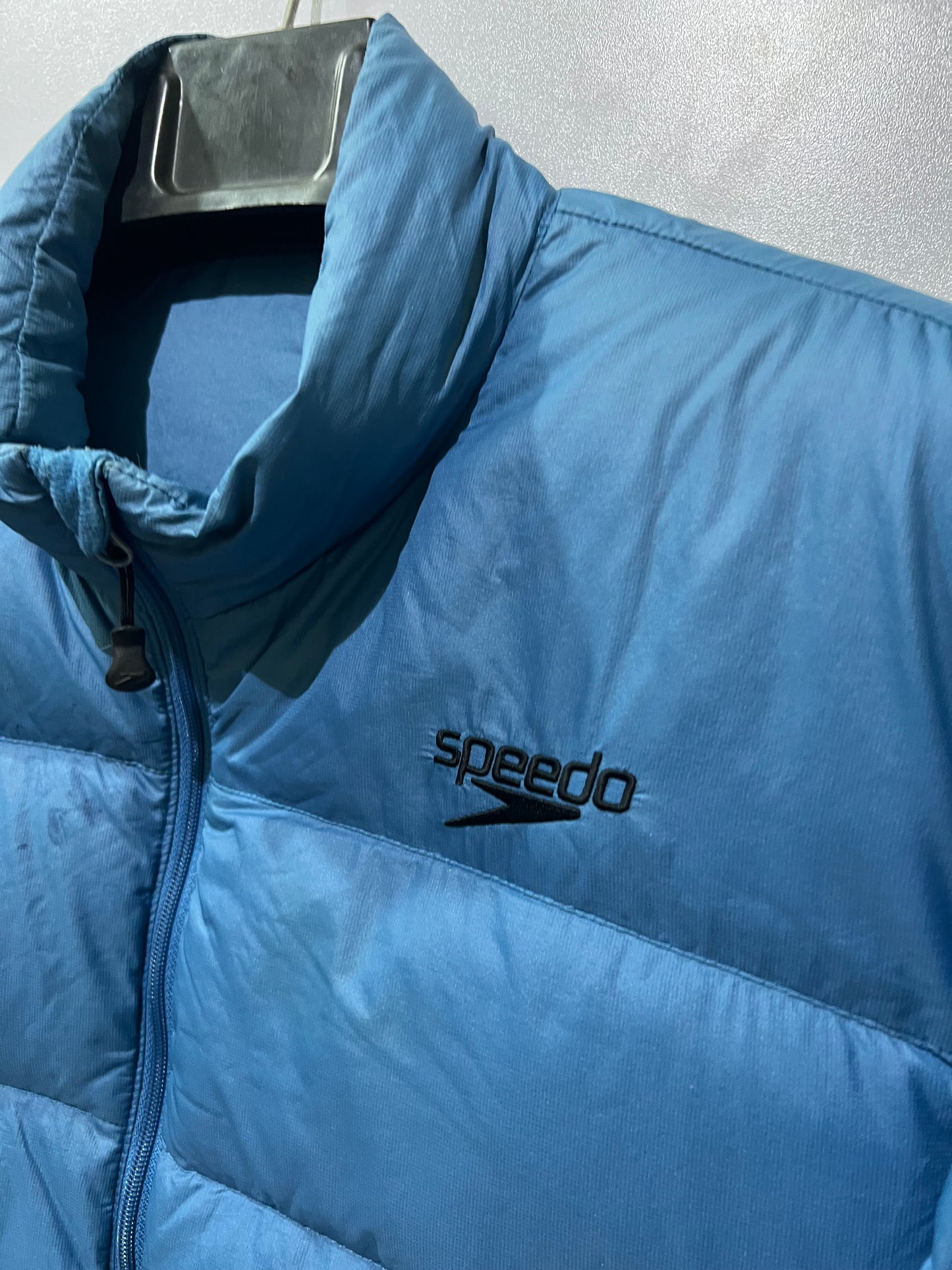 Speedo puffer jacket features a high collar and quilted construction for warmth.