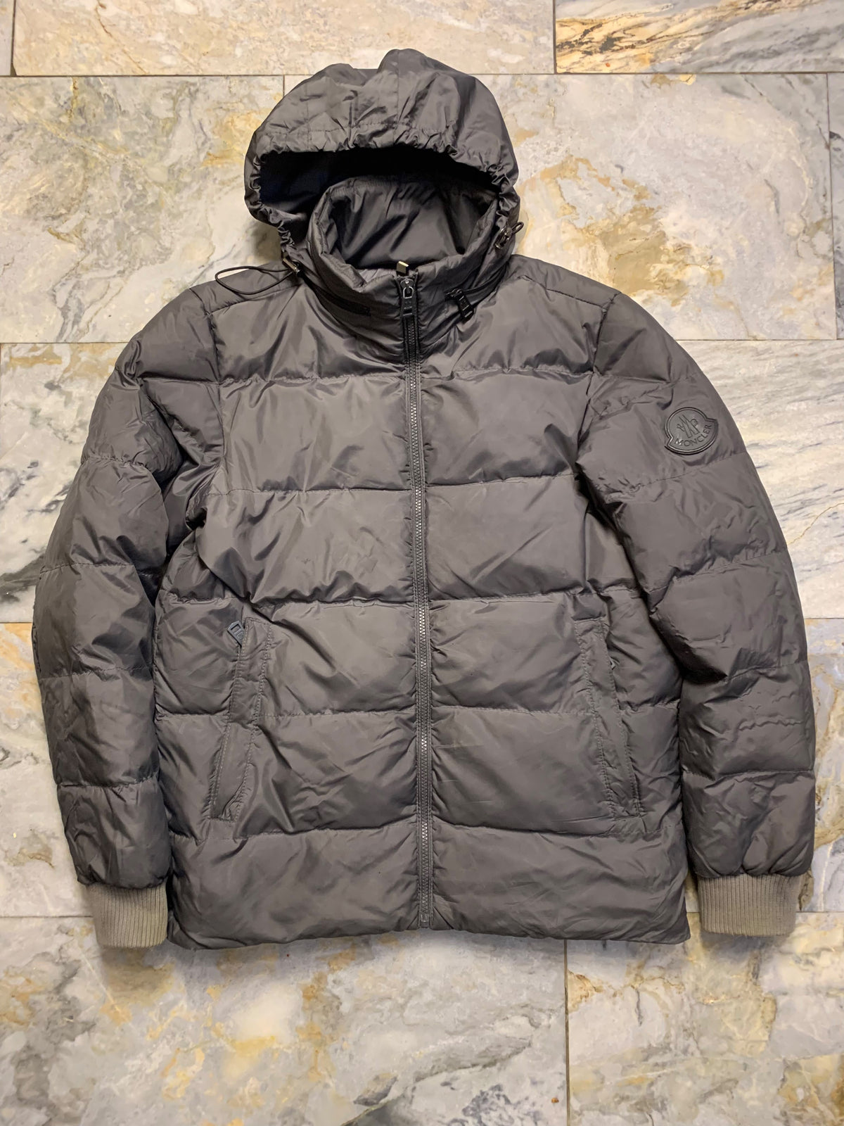 Moncler logo patch on the left sleeve, resembling a Moncler down jacket. [1]