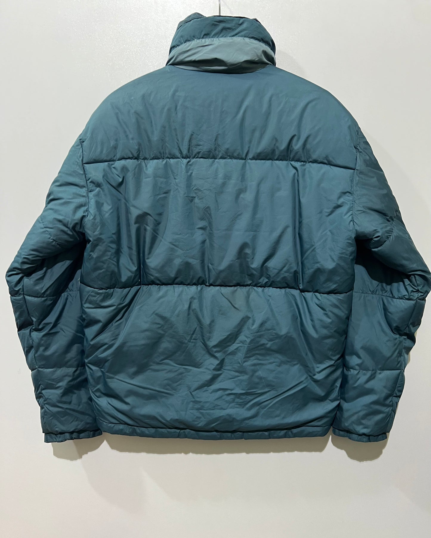 vintage teal Helly Hansen puffer jacket features a prominently embroidered logo