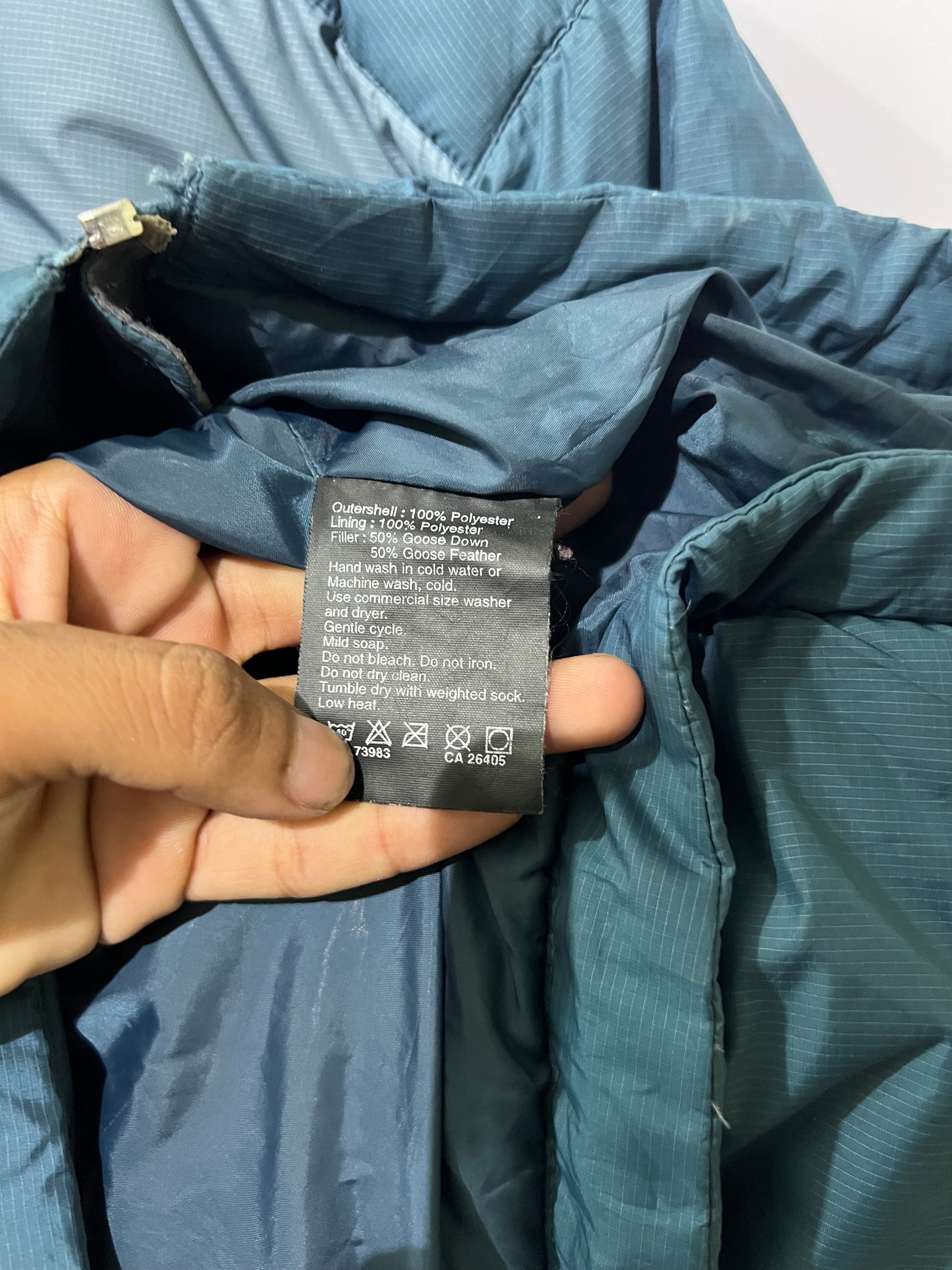 vintage teal Helly Hansen puffer jacket features a prominently embroidered logo