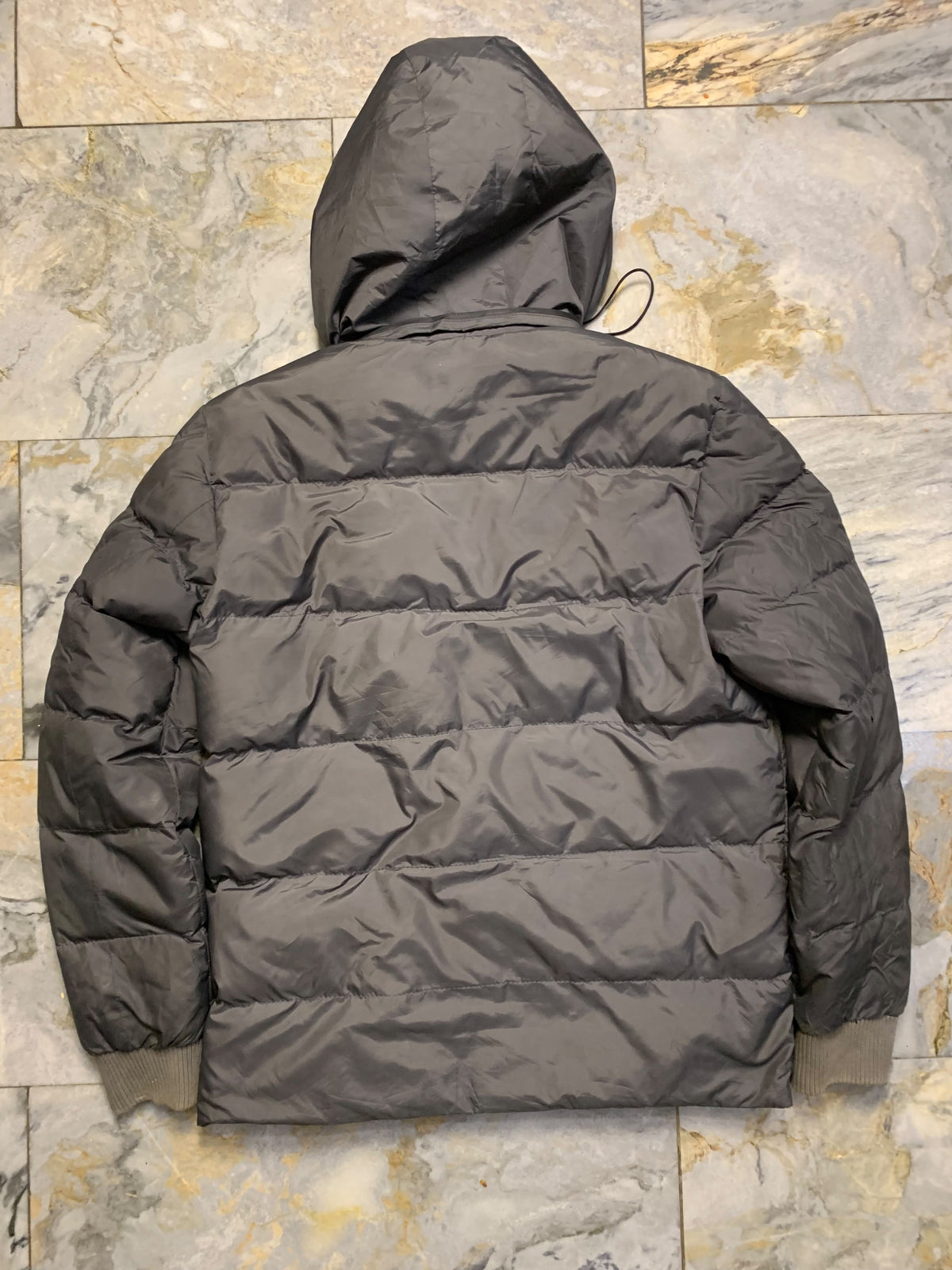 Moncler logo patch on the left sleeve, resembling a Moncler down jacket. [1]
